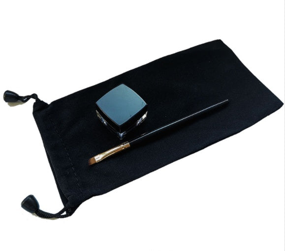 Black pouch with a blue compact and a black and gold brush on a white background